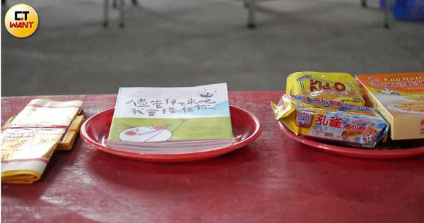 郭源元拿出一月剛推出的新書，與餅乾一起放在供桌上求神明保佑。（圖／本刊攝影組）