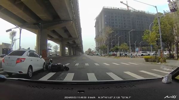 騎士綠燈馬上左切，撞上汽車摔倒。（圖／翻攝自Facebook／爆料公社）