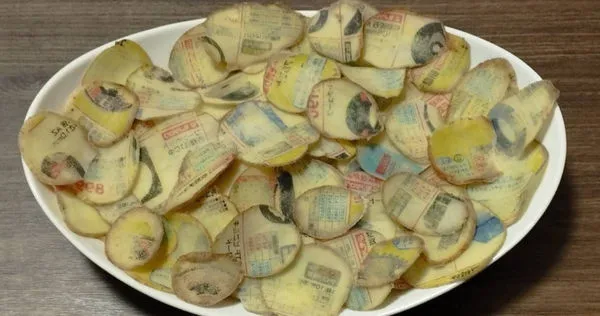 日本網友將洋芋片夾進型錄吸乾水份，結果文字跟圖案全轉印到上面。（圖／翻攝X／＠murataart）