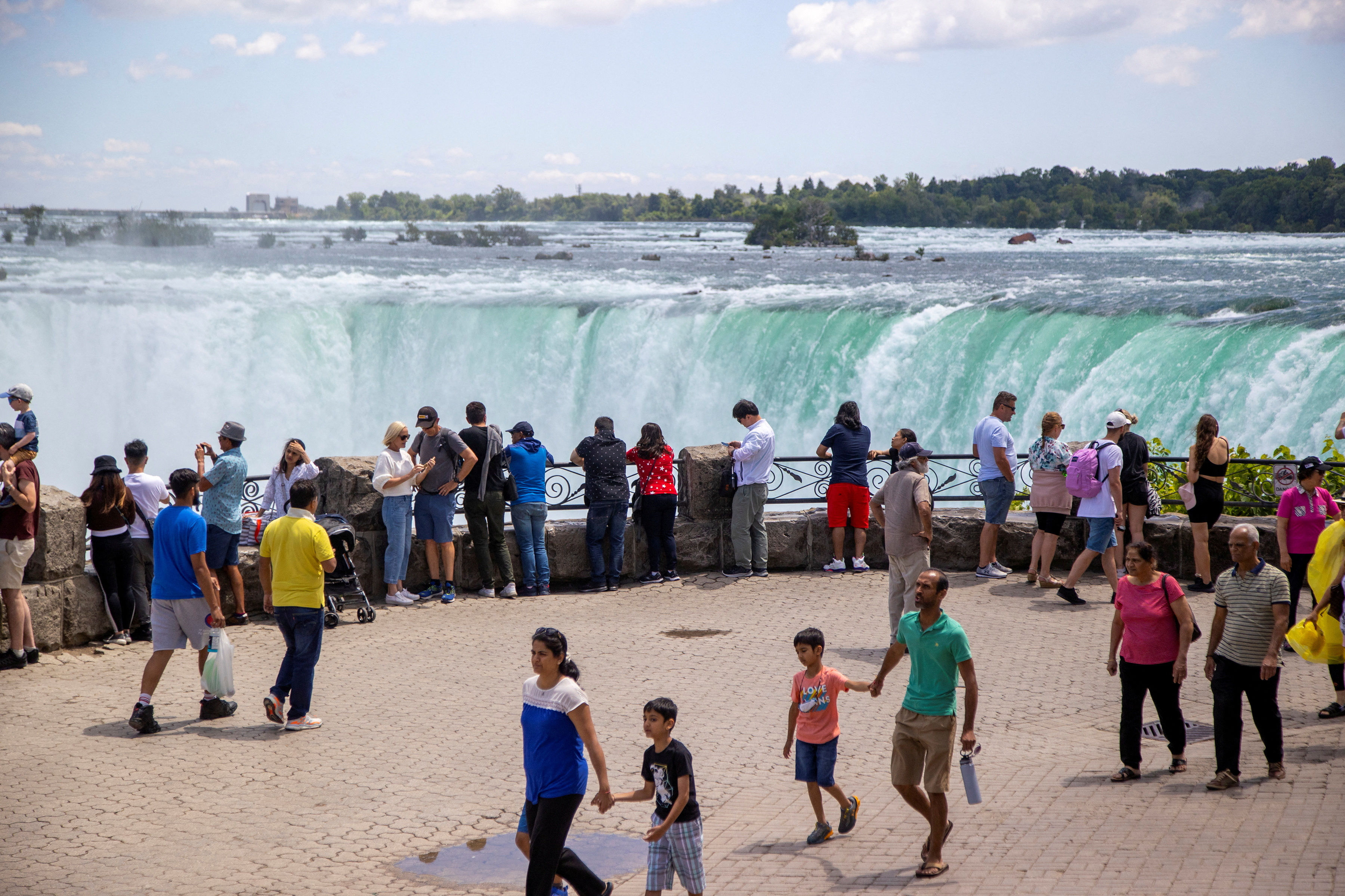▲▼  圖為加拿大安大略省尼加拉瀑布（Niagara Falls）2022年遊客在景點前拍照。（圖／路透）