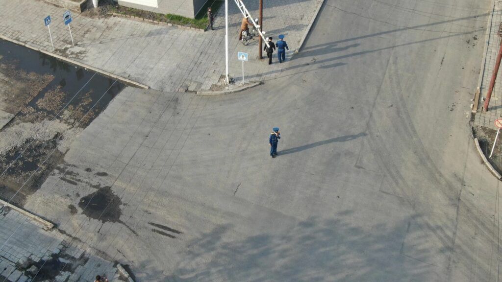 ▲▼一名網友透過操縱無人機從中國空拍北韓新義州市，可以看見冷清的街道和懸掛金氏父子肖像的建築物。（圖／翻攝自Reddit）