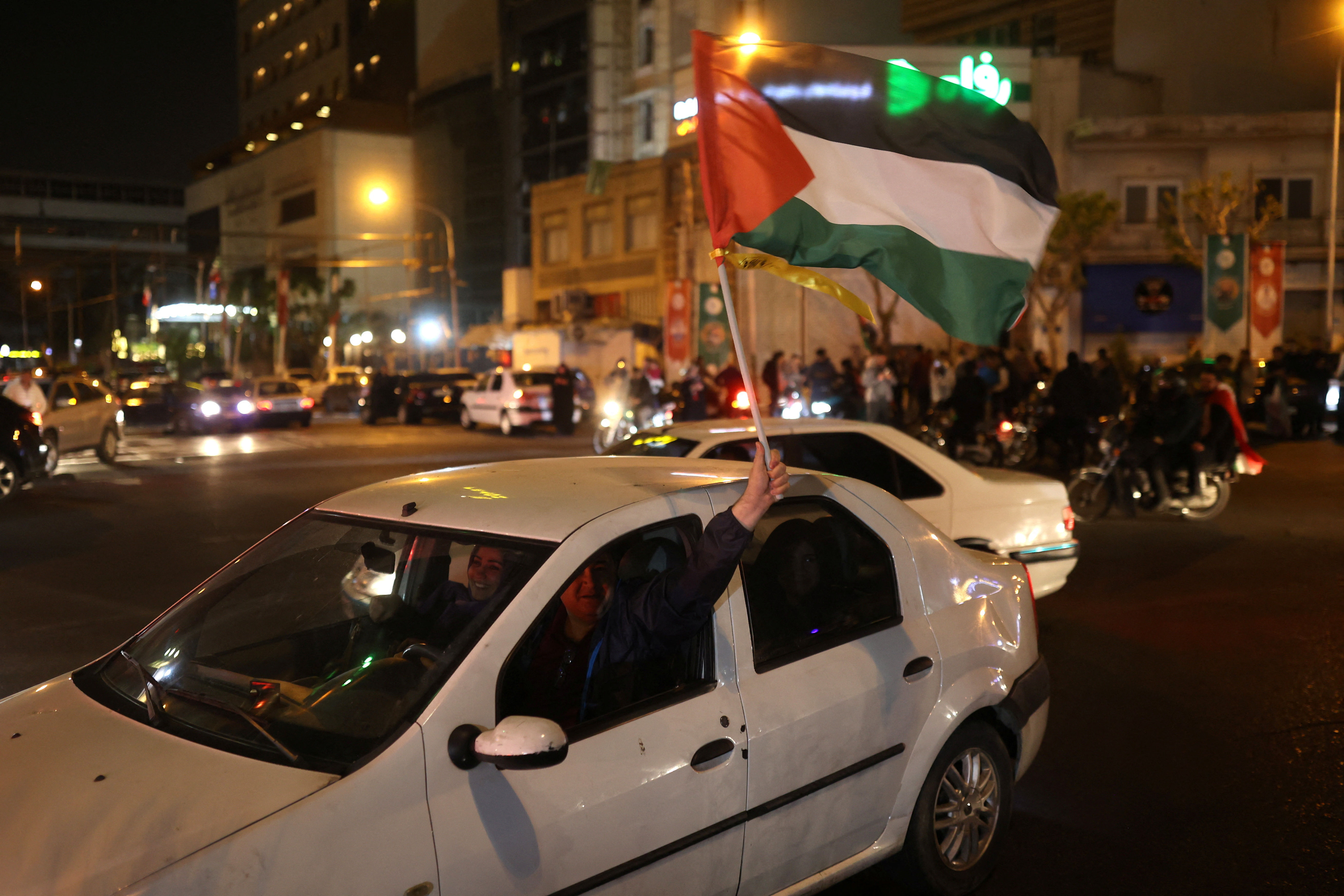 ▲▼ 伊朗攻擊以色列之後，伊朗男子14日揮舞巴勒斯坦旗幟慶祝。（圖／路透）