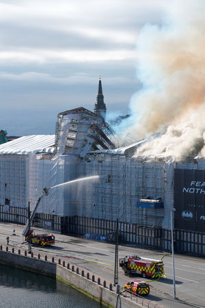 ▲▼丹麥首都哥本哈根（Copenhagen）400年歷史的舊證券交易所發生大火，高達56公尺的「4龍纏尾」造型螺旋尖塔也被烈焰吞噬。（圖／路透）