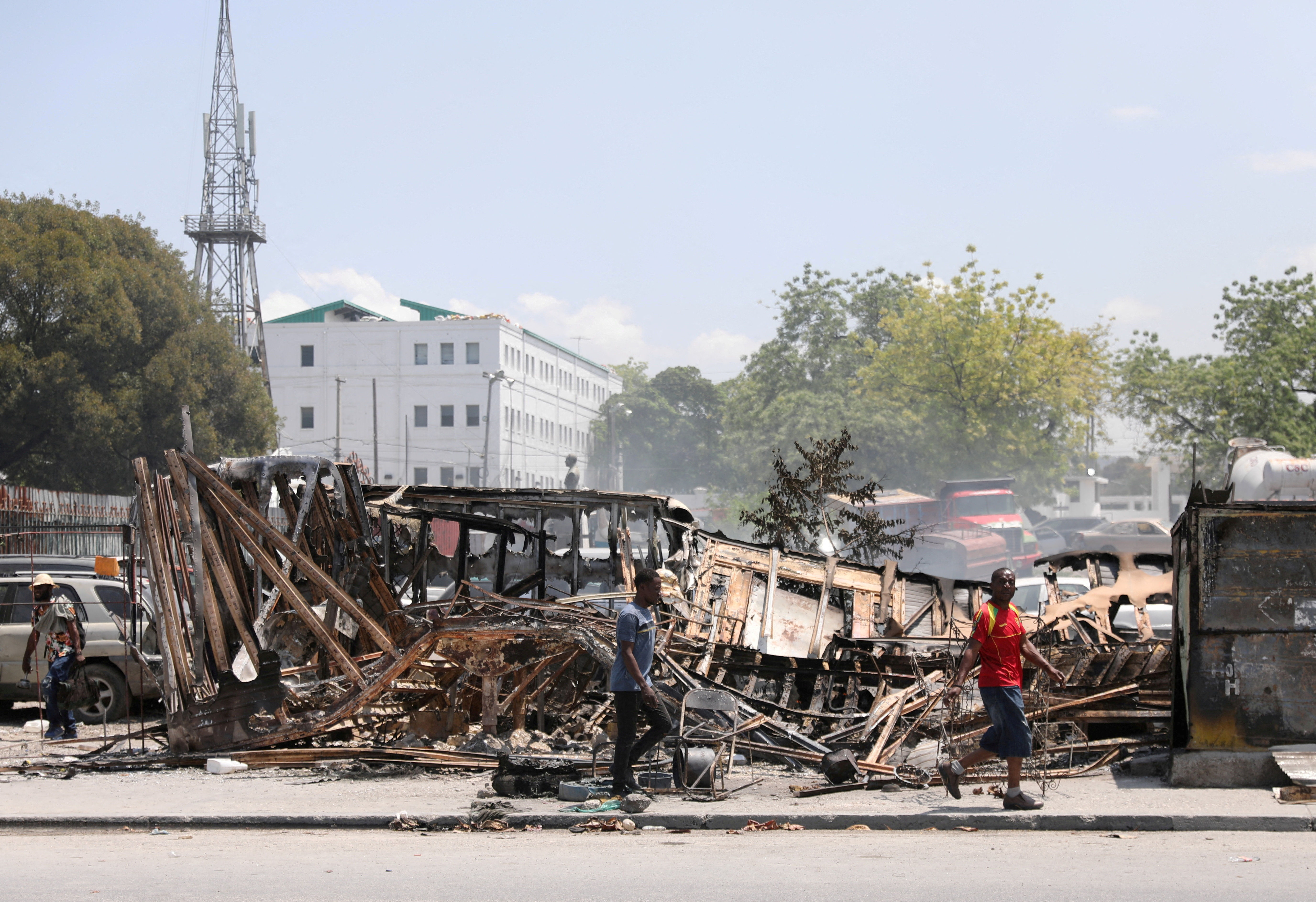 ▲▼  海地太子港2024年3月，民眾路過被幫派縱火焚燒的車輛殘骸。（圖／路透）