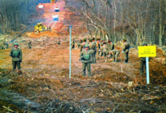 ▲▼2018年11月，南北韓為了挖掘韓戰烈士遺骸，在江原道鐵原郡箭頭高地興建道路，雙方軍人握手問候。（圖／大韓民國國防部）