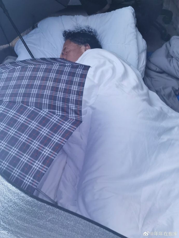 ▲大陸病毒專家郭永振在雨夜中睡在實驗室大門口表達抗議。（圖／翻攝微博）