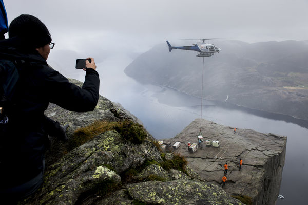 ▲▼挪威著名旅遊景點聖壇岩（Preikestolen，又譯布道台）曾是好萊塢巨星湯姆克魯斯主演電影《不可能的任務》的取景地。圖為2017年製片方將拍攝設備以直升機垂降到這處600公尺高的懸崖上。（圖／達志影像／美聯社）