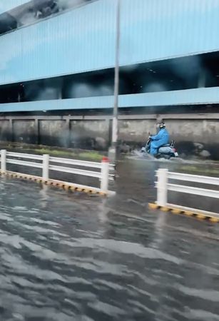 ▲▼ 雨彈開炸！高雄馬路驚變「漂漂河」　騎士逃上人行道驚險通過。（圖／翻攝記者爆料網）