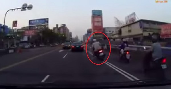 機車騎士違規雙白線超車，卻被中間的反光柱「彈」到禁行機車道。（圖／翻攝自YouTube）