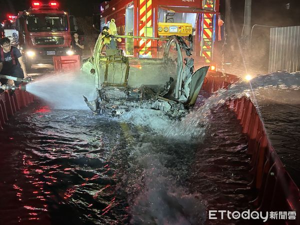 ▲特斯拉起火，電池持續熱反應，警消人員運用防汛擋板「建水池」泡水降溫。（圖／記者蔡佩旻攝）