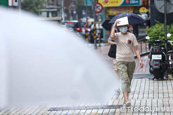 ▲6月21日夏至，台北地區下起午後雷陣雨，民眾連忙躲雨。（圖／記者林敬旻攝）