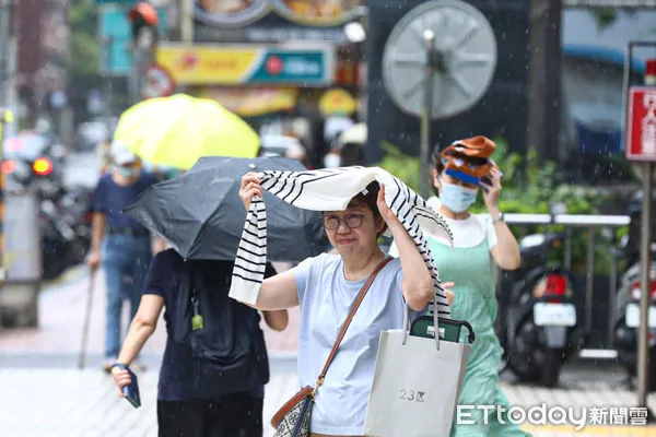 ▲6月21日夏至，台北地區下起午後雷陣雨，民眾連忙躲雨。（圖／記者林敬旻攝）