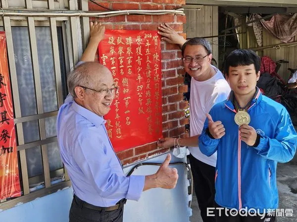 ▲家扶童陳宇祺同學代表國家優秀的健力戰績，雲林家扶主委陳燦勳與主任廖志文，貼紅榜祝賀。（圖／記者蔡佩旻翻攝）