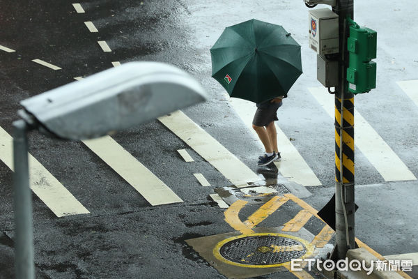 ▲▼凱米颱風逐漸遠離，北市街頭風雨趨緩,天氣,行人路權,路人,雷雨,口罩,斑馬線,過馬路,大雨,大雷雨,下雨,雨天,豪大雨,午後雷陣雨,梅雨,降雨,氣象,豪雨,颱風外圍環流,西南氣流,滯留鋒面,撐傘,雨傘,陰雨綿綿,潮濕,濕度,熱對流,天氣配圖。（圖／記者李毓康攝）