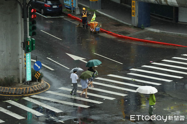 ▲▼凱米颱風逐漸遠離，北市街頭風雨趨緩,天氣,行人路權,路人,雷雨,口罩,斑馬線,過馬路,大雨,大雷雨,下雨,雨天,豪大雨,午後雷陣雨,梅雨,降雨,氣象,豪雨,颱風外圍環流,西南氣流,滯留鋒面,撐傘,雨傘,陰雨綿綿,潮濕,濕度,熱對流,天氣配圖。（圖／記者李毓康攝）