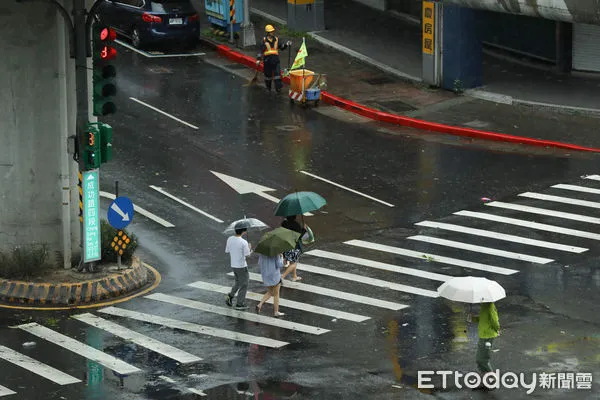 ▲▼凱米颱風逐漸遠離，北市街頭風雨趨緩,天氣,行人路權,路人,雷雨,口罩,斑馬線,過馬路,大雨,大雷雨,下雨,雨天,豪大雨,午後雷陣雨,梅雨,降雨,氣象,豪雨,颱風外圍環流,西南氣流,滯留鋒面,撐傘,雨傘,陰雨綿綿,潮濕,濕度,熱對流,天氣配圖。（圖／記者李毓康攝）