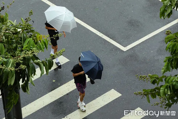 ▲▼凱米颱風逐漸遠離，北市街頭風雨趨緩,天氣,行人路權,路人,雷雨,口罩,斑馬線,過馬路,大雨,大雷雨,下雨,雨天,豪大雨,午後雷陣雨,梅雨,降雨,氣象,豪雨,颱風外圍環流,西南氣流,滯留鋒面,撐傘,雨傘,陰雨綿綿,潮濕,濕度,熱對流,天氣配圖。（圖／記者李毓康攝）