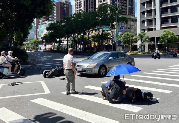 ▲▼劉姓騎士幫女友撐傘等待救護車             。（圖／記者陳以昇翻攝）