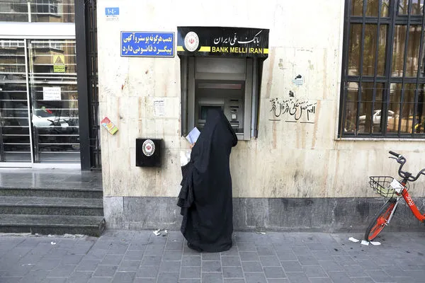 ▲▼伊朗首都德黑蘭一名婦女在使用伊朗國家銀行（Bank Melli Iran）的提款機（ATM）。（圖／達志影像／美聯社）