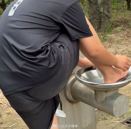 有遊客直接將腳放進飲水機水池內洗腳，模樣十分噁心。（翻攝微博）