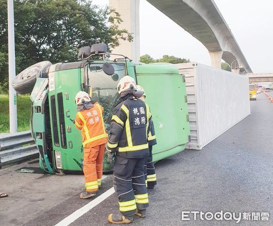 ▲國道桃園機場系統北上52.5公里處今天清晨發生貨櫃車翻覆事故，警消已配壞器材救出受困駕駛。（圖／記者沈繼昌翻攝）