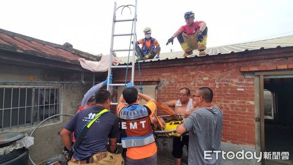 ▲台南市麻豆區1名90歲男子在住家進行屋頂作業時不慎跌落，導致腳部受傷被困屋頂高處，消防人員立即運用繩索技術救援傷者送醫。（圖／記者林東良翻攝，下同）