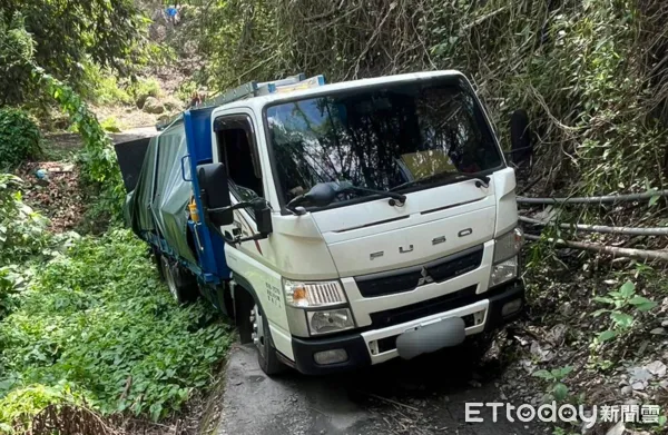 ▲3噸半貨車車輪陷落山壁，信義分局員警協助道路救援。（圖／記者高堂堯翻攝）