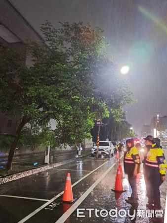 ▲隨著颱風逼近風雨逐漸明顯，台南市中西區南門路中山館前路樹晚上傾斜，造成道路險象環生，二分局警方冒雨警戒查處。（圖／記者林東良翻攝，下同）