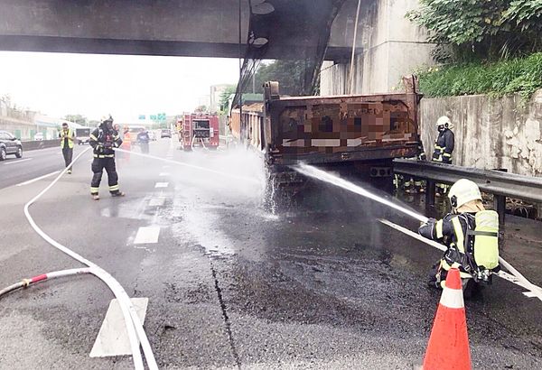 ▲國道2號西向八德段下午3時許發生行駛中砂石車左後輪突然竄出大火，消防人員灌救中。（圖／桃園市消防局提供）