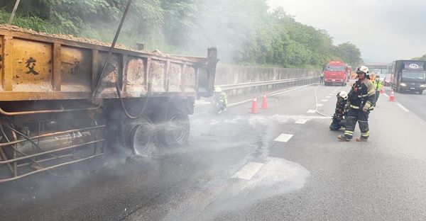 ▲桃園市消防人員撲滅火勢後，砂石車左後輪僅剩下鋼圈。（圖／桃園市消防局提供）