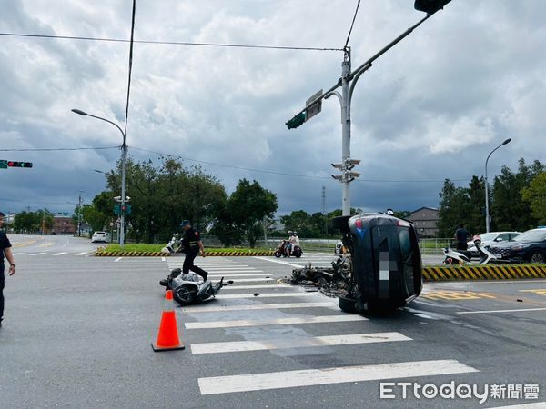 ▲▼黑色休旅車在路口的中央分隔島處，撞機車，也撞斷分隔島警示標誌桿，車頭全毀一度冒煙的右側翻在斑馬線旁。（圖／記者游芳男翻攝，下同）