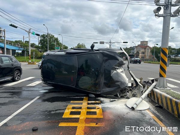 ▲▼黑色休旅車在路口的中央分隔島處，撞機車，也撞斷分隔島警示標誌桿，車頭全毀一度冒煙的右側翻在斑馬線旁。（圖／記者游芳男翻攝，下同）