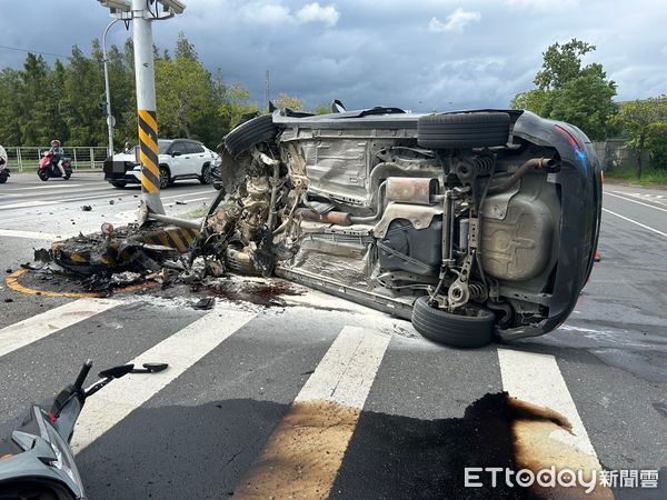 ▲▼黑色休旅車在路口的中央分隔島處，撞機車，也撞斷分隔島警示標誌桿，車頭全毀一度冒煙的右側翻在斑馬線旁。（圖／記者游芳男翻攝，下同）