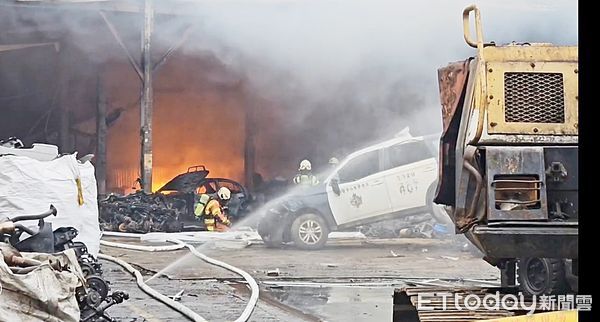 ▲桃園市桃園區鹽庫街一家汽車回收場今天下午發生大火，消防人員架設水線灌救。（圖／記者沈繼昌翻攝）