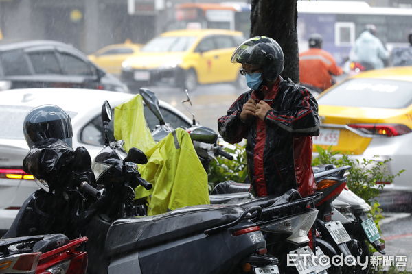 ▲▼受颱風外圍環流及東北季風雙重影響下，大台北及宜蘭地區降下驚人雨量，氣溫也明顯下獎。台北街頭行人紛紛穿戴雨具，穿起保暖衣物。（圖／記者湯興漢攝）