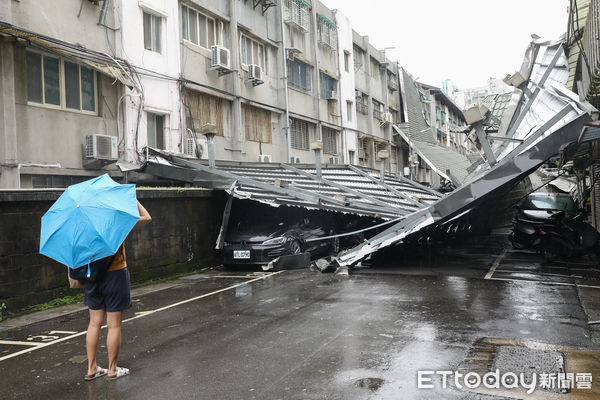 ▲▼康芮颱風狂風豪雨一夜橫掃全台，北市延壽街402巷一處公家宿舍頂樓鐵皮屋頂被強風吹落，擋住整條街道通行，至今（1）日早上仍等待相關單位處理。（圖／記者李毓康攝）