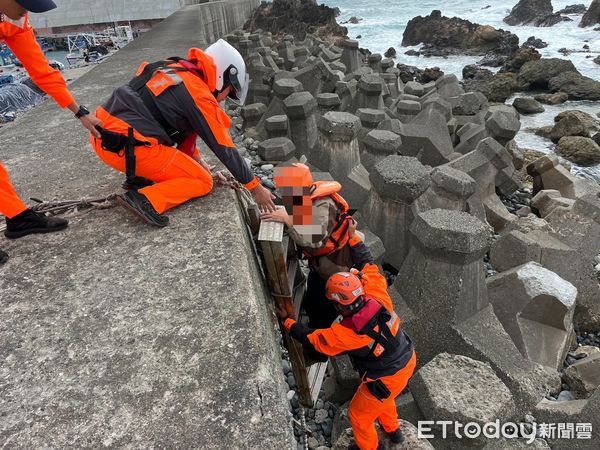 ▲海巡人員協助民眾爬上消波塊。（圖／記者楊漢聲翻攝）