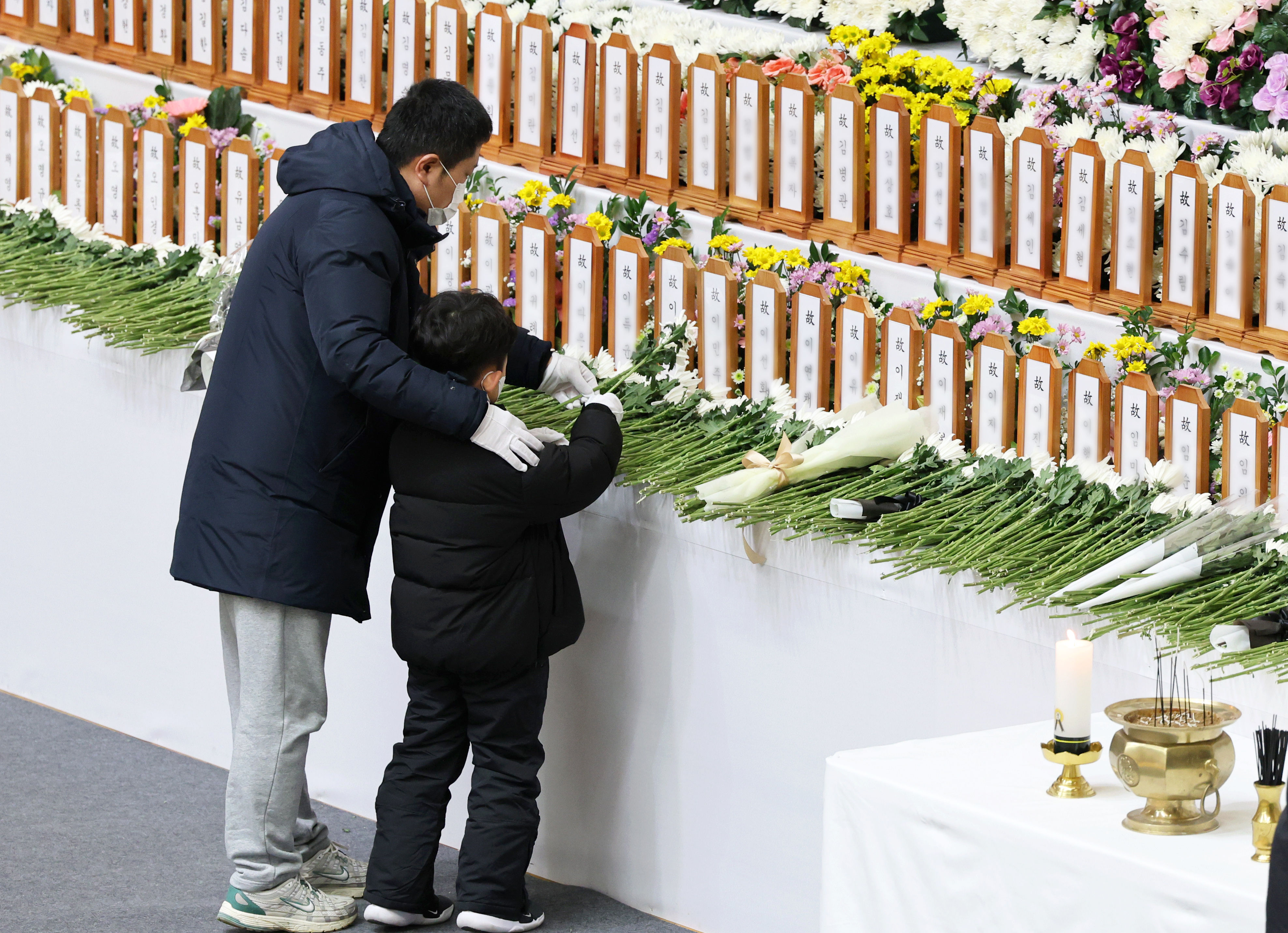 ▲▼家屬帶著孩子前往務安機場焚香所悼念空難死者。（圖／達志影像）