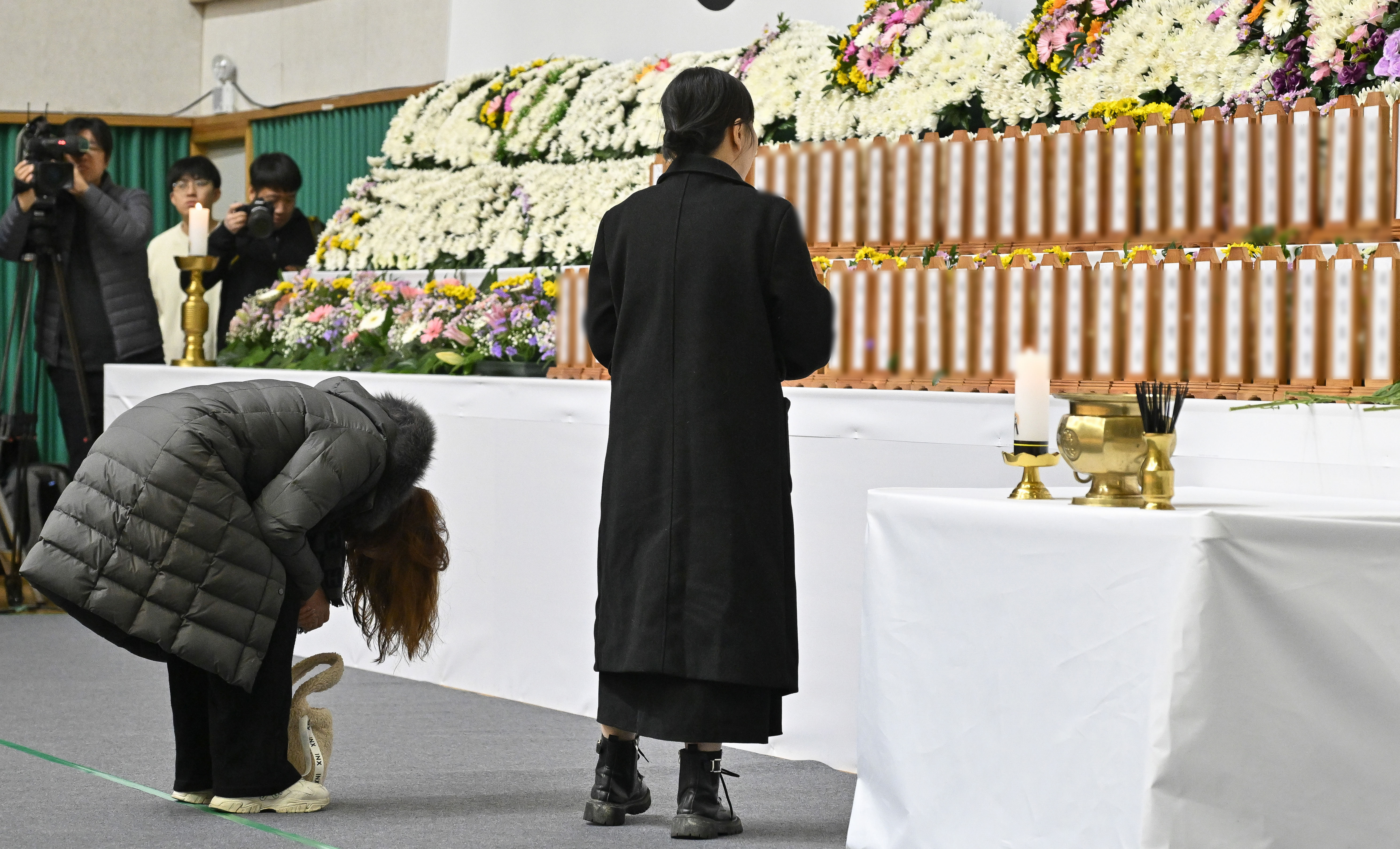 ▲▼南韓務安國際機場1樓設置聯合焚香所，家屬前往獻花悼念，神情哀悽。（圖／達志影像／newscom）