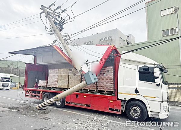 ▲一輛大貨車昨天下午行經桃園市蘆竹區海湖北路時，忘關鷗翼門導致撞斷台電電線桿，警方到場進行交通疏導。（圖／記者沈繼昌翻攝）