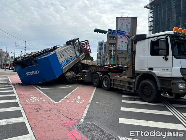 ▲▼蘆洲捷運站外，一輛聯結車載運吊車，疑似未固定好突然滑動掉落馬路            。（圖／記者陸運陞翻攝）