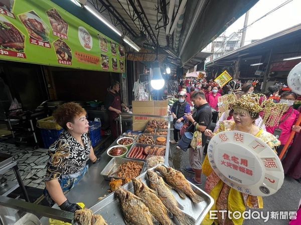 ▲台南市永康區兵仔市場採購年貨人潮湧現，25日上午消防局第五大隊復興消防分隊警消率義消及大灣婦女防火宣導隊至市場內向採買的民眾及攤商們進行各式消防觀念宣導。（圖／記者林東良翻攝，下同）