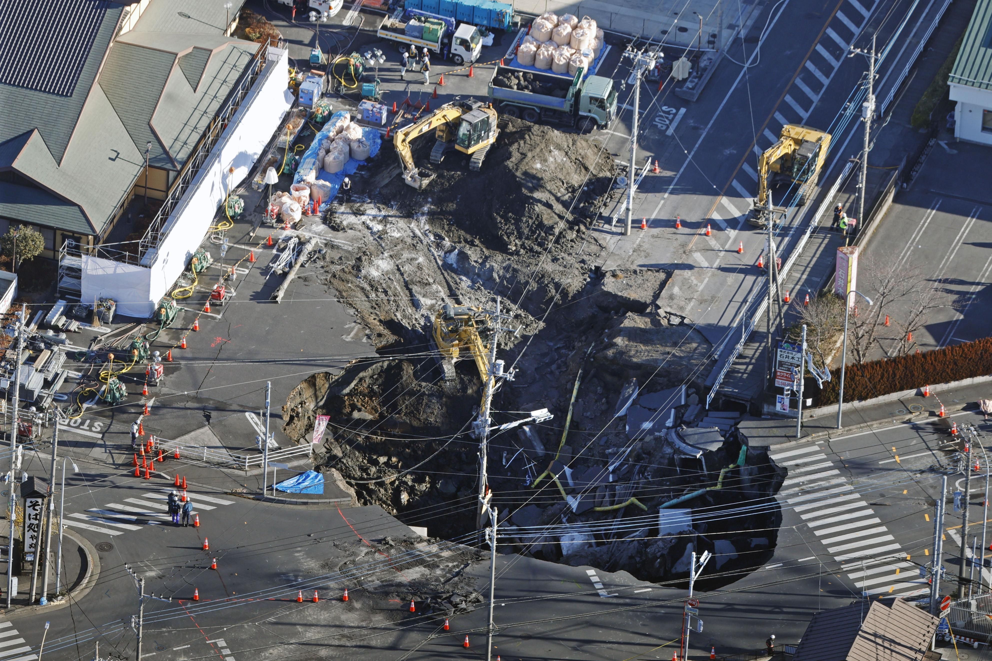 ▲▼日本埼玉縣八潮市縣道十字路口出現巨大天坑，深度達15公尺，跟著卡車墜落天坑的74歲男駕駛生死不明。（圖／達志影像）