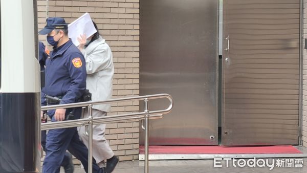 ▲▼涉虐死1歲男童剴剴的冷血保母姊姊劉彩萱，5日到台北地院出庭後還押，用文件遮臉躲避媒體鏡頭。（圖／記者黃哲民攝）