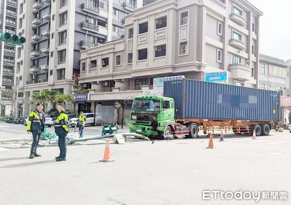 ▲一輛貨櫃車今天上午行經中壢區松勇路附近時，因左前輪爆胎導致失控撞擊路旁廣告招牌與號誌電桿，員警到場處理。（圖／記者沈繼昌翻攝）