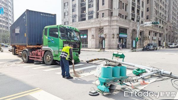 ▲一輛貨櫃車今天上午行經中壢區松勇路附近時，失控撞壞廣告招牌與號誌電桿，警方聯繫環管處人員到場清理。（圖／記者沈繼昌翻攝）