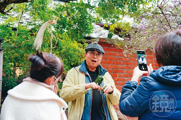 林三元（中）在街頭進行草編創作時，會與遊客熱烈互動，讓人忍不住拿起手機記錄過程。