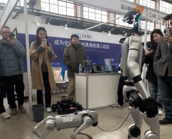 ▲▼  宇樹科技人形機器人遛機器狗           。（圖／翻攝 澎湃新聞）