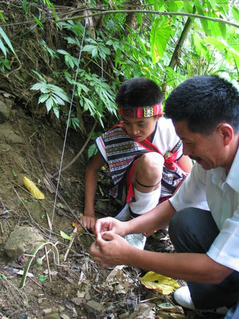 苗栗縣泰安鄉原住民楊基富教導部落少年以竹子、木頭與麻繩編製抓山豬的陷阱，如今「山豬吊」等金屬獵具盛行，原住民傳統狩獵方式儘管傷害較小卻顯得費工，也讓傳承出了問題。（圖／報系資料庫）