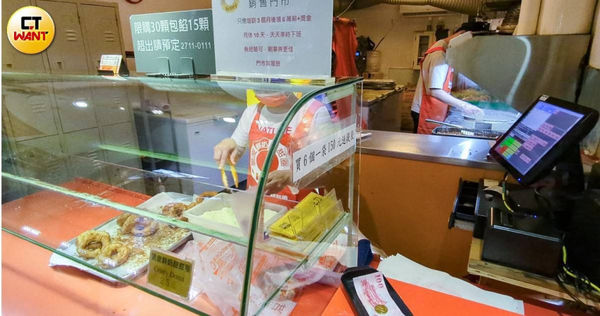 甜甜圈店的櫃檯上放著大大的徵人廣告，打出「月薪6萬+獎金」、「天天準時下班」等語，對比前員工所遭遇到的事情顯得相當諷刺。（圖／林冠吟攝）